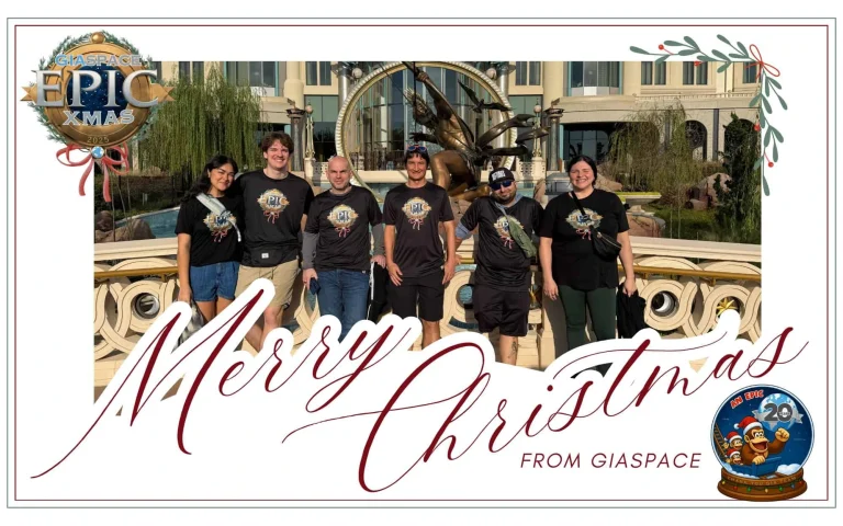 Six people in matching black shirts pose in front of a fountain on a festive 'Merry Christmas' banner with decorative border.