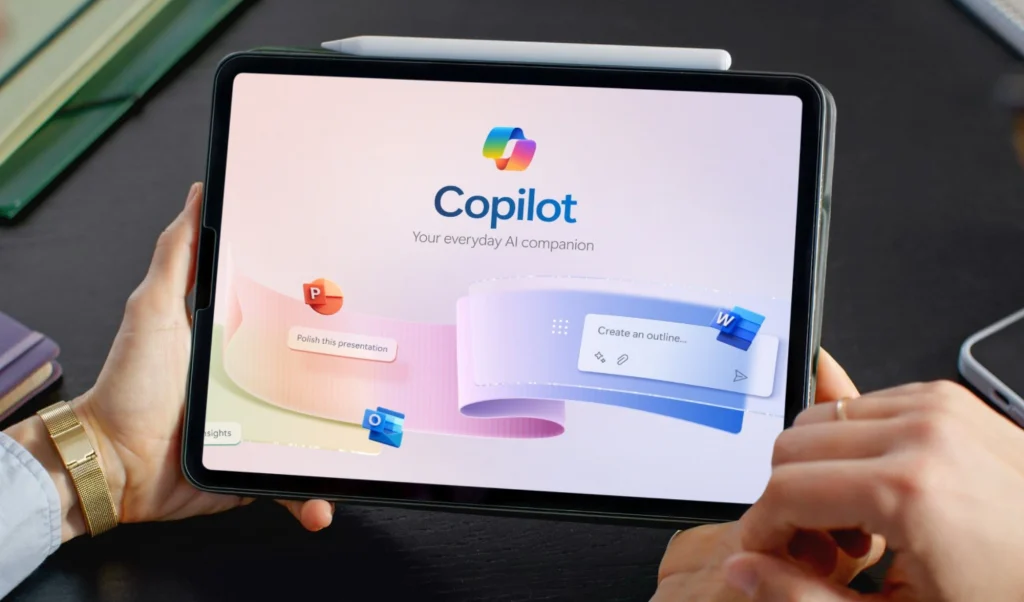 Tablet held in hands showing Copilot branding and slogan 'Your everyday AI companion' on a colorful UI backdrop.